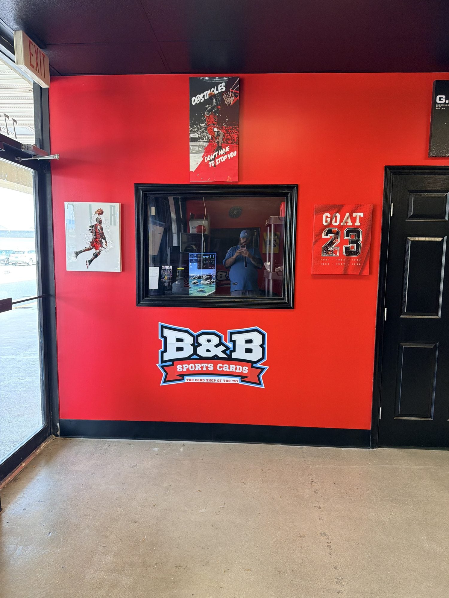 Red wall with the big B&B Sports Cards logo and buy window at the new Virginia Beach shop